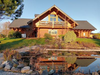 Magnificent log chalet set in 1 ha of wooded grounds. Balconies, terraces, parking, habitable on one level.