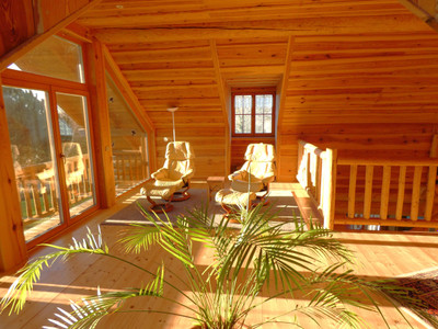 Magnificent log chalet set in 1 ha of wooded grounds. Balconies, terraces, parking, habitable on one level.