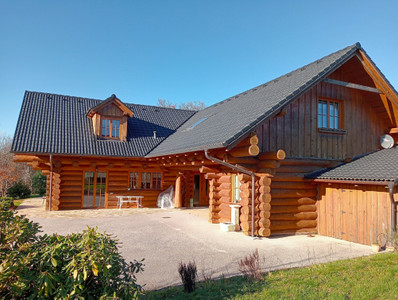 Magnificent log chalet set in 1 ha of wooded grounds. Balconies, terraces, parking, habitable on one level.